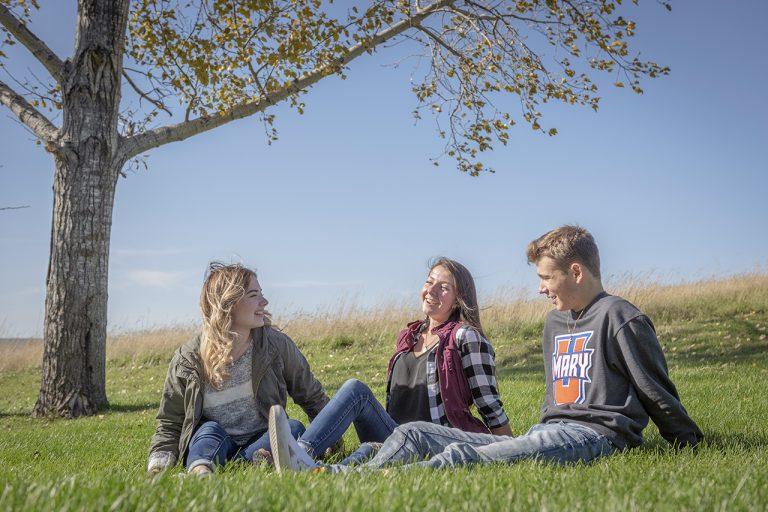 Alexa Leingang, center, hangs out with friends enjoying the fall day on campus.