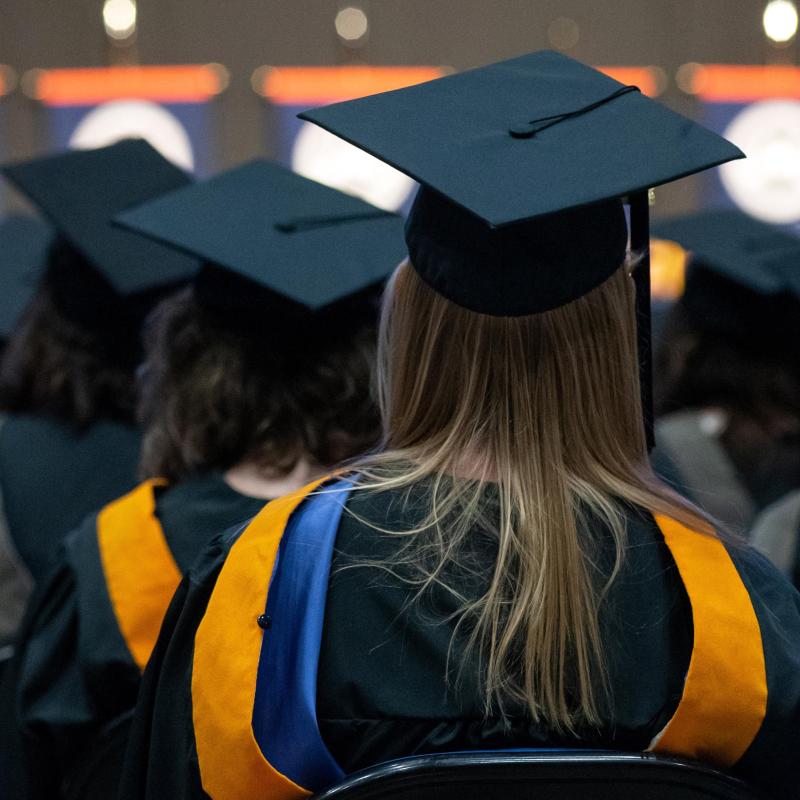 A University of Mary student sitting at commencement.