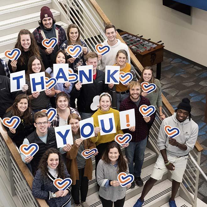 Group of students holding thank you signs for the University of Mary’s giving day.