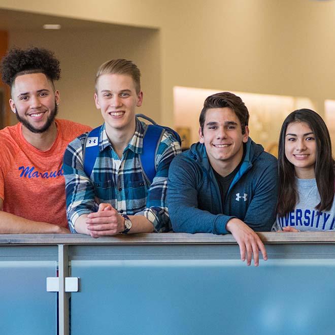 Four students smiling at the camera