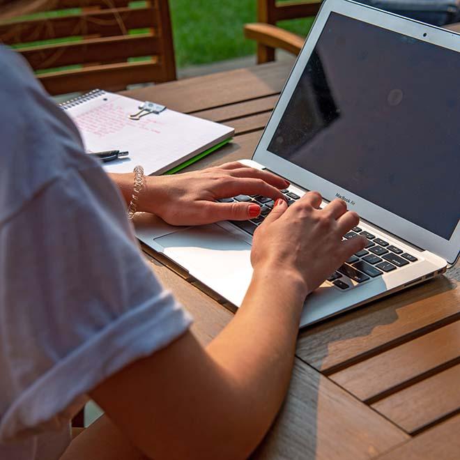 Smiling female student in residence hall studying on laptop