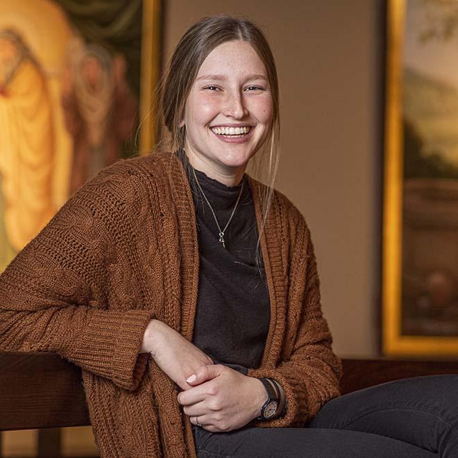 Smiling, female student in the chapel of one of the University of Mary residence halls. 