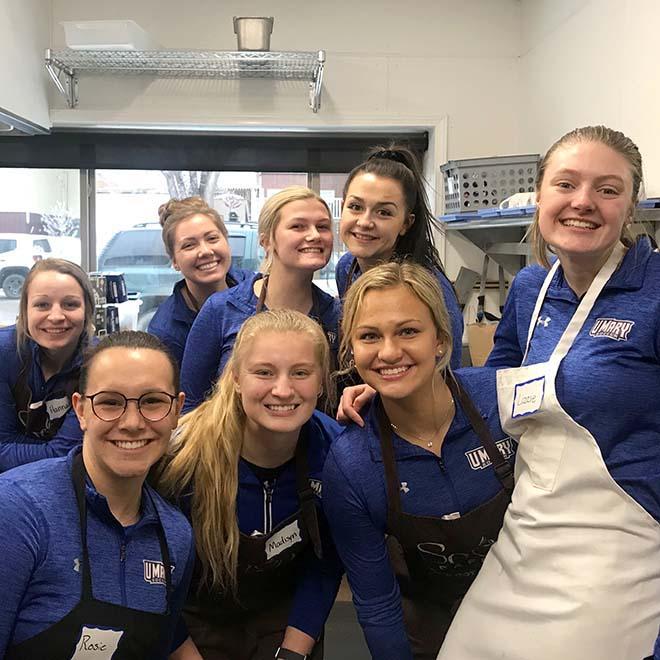 Group of smiling students volunteering at soup kitchen