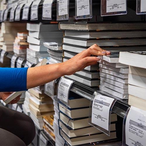 Hand reaching for a textbook in the bookstore.