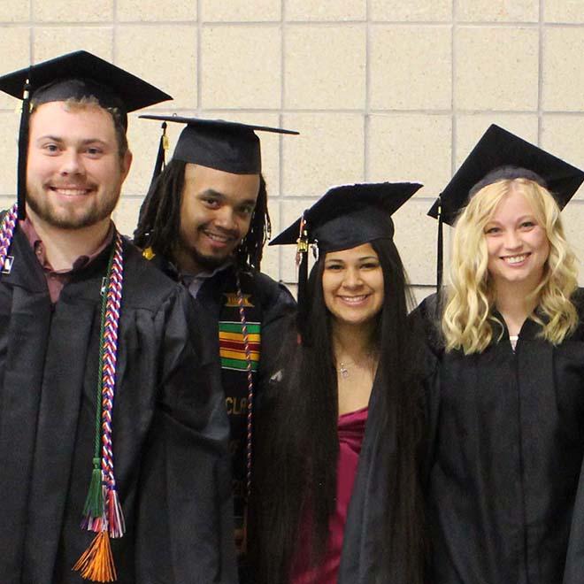 Four TRIO students in their graduation attire.