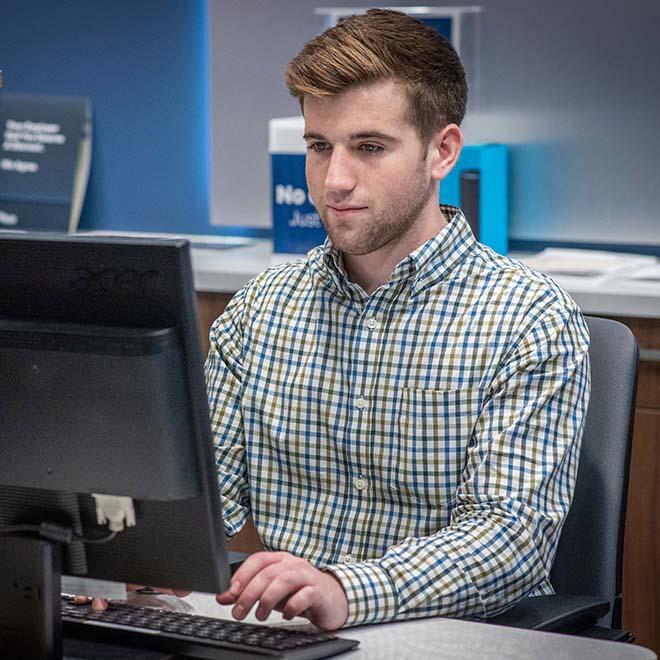 College student working at computer as part of internship