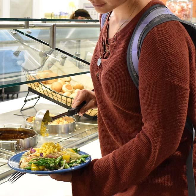 Student filling plate at campus restaurant