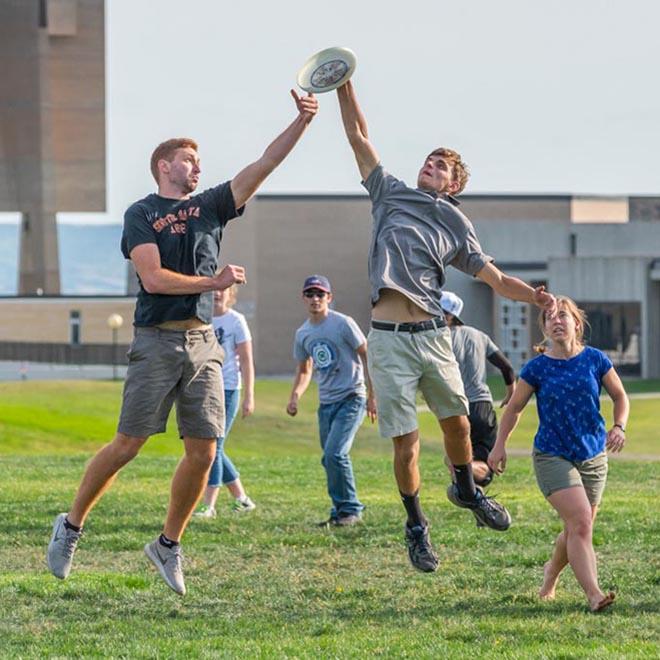 Group of students playing frisbee on the shire.