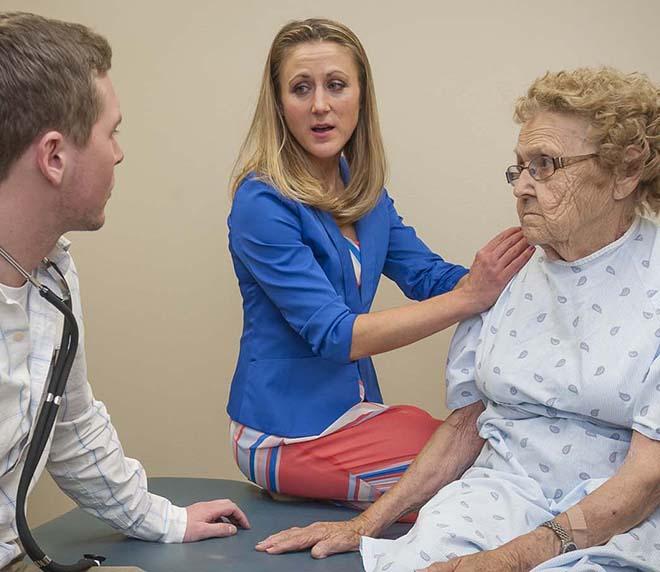 Physical therapy doctoral student and instructor meet with elderly client at the physical therapy clinic