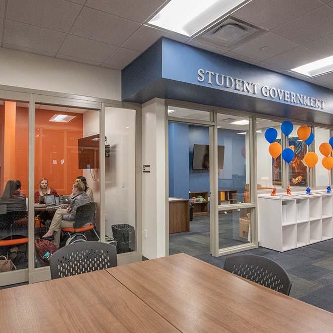 View outside Student Government space with students meeting in room alongside