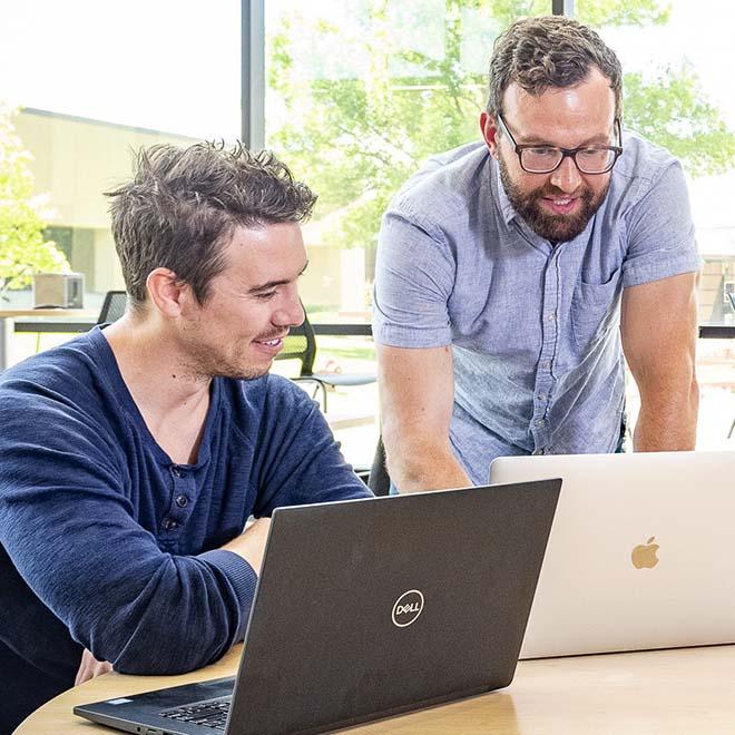 Two men meeting and looking at computers