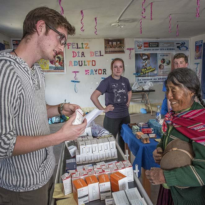 Male student discussing prescriptions with Peruvian woman