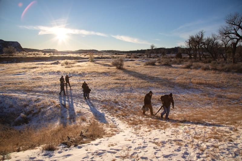 Filming crew carrying equipment in the winter snow