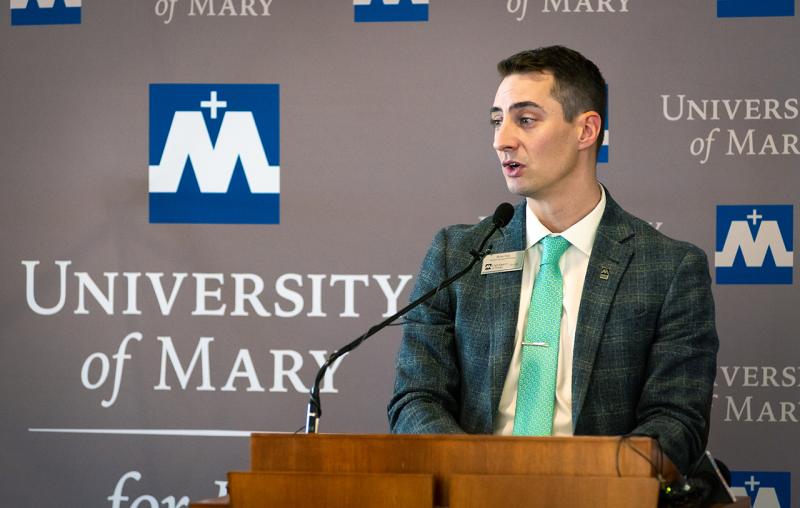 Brian Opp speaking at a podium