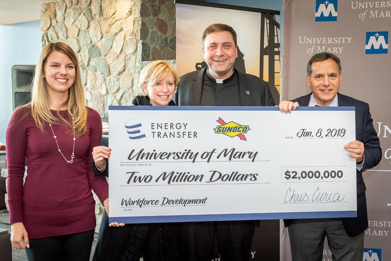 Monsignor Shea and others standing with a large check