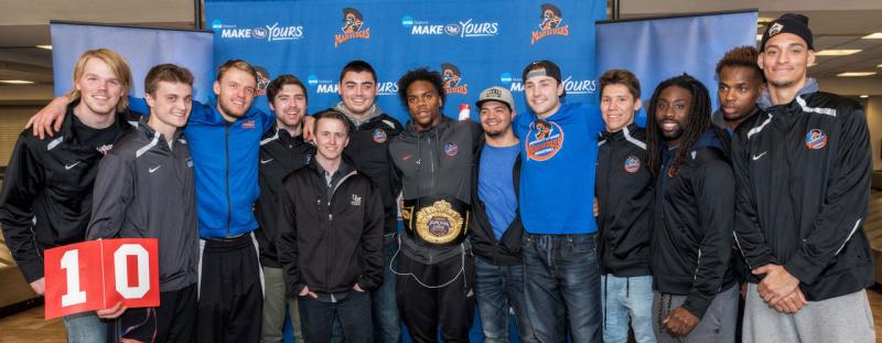 University of Mary’s Devan Douglas is welcomed home by Marauders at the Bismarck Airport. Here he poses for a photo with his Marauders teammates after winning the national State Farm College Championship