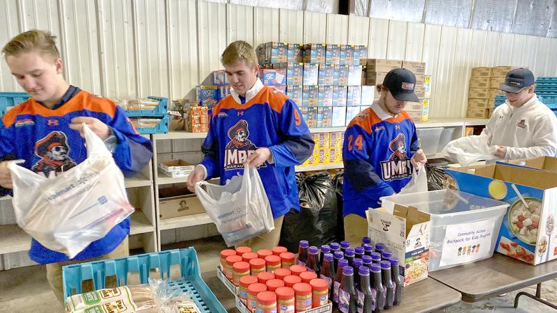 Hockey Team Working on filling bags of food for the food pantry