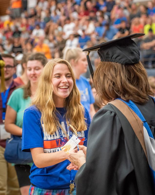 Students receives traditional wheat stalk during the Welcome Week ceremony.