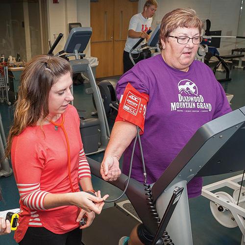 Exercise Science Student working with a patient on the treadmill