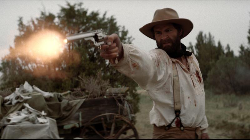 Man firing gun in western attire
