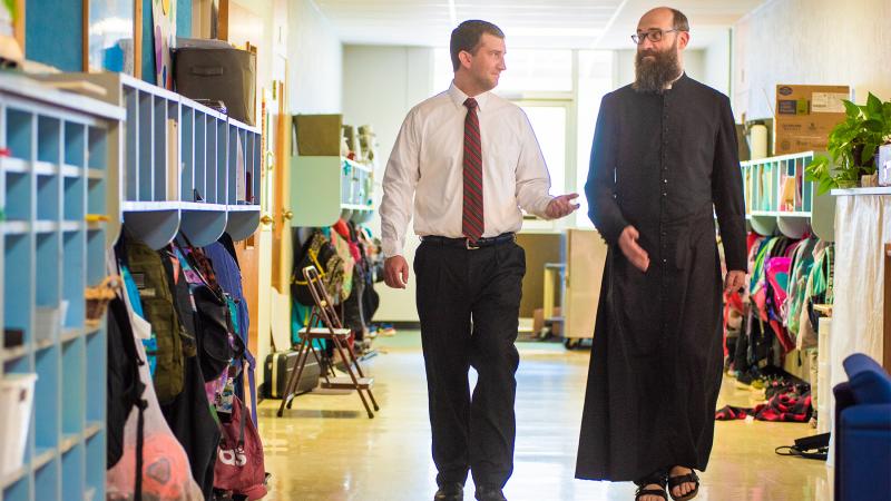 Fr Schneider and the Principal walking down the halls