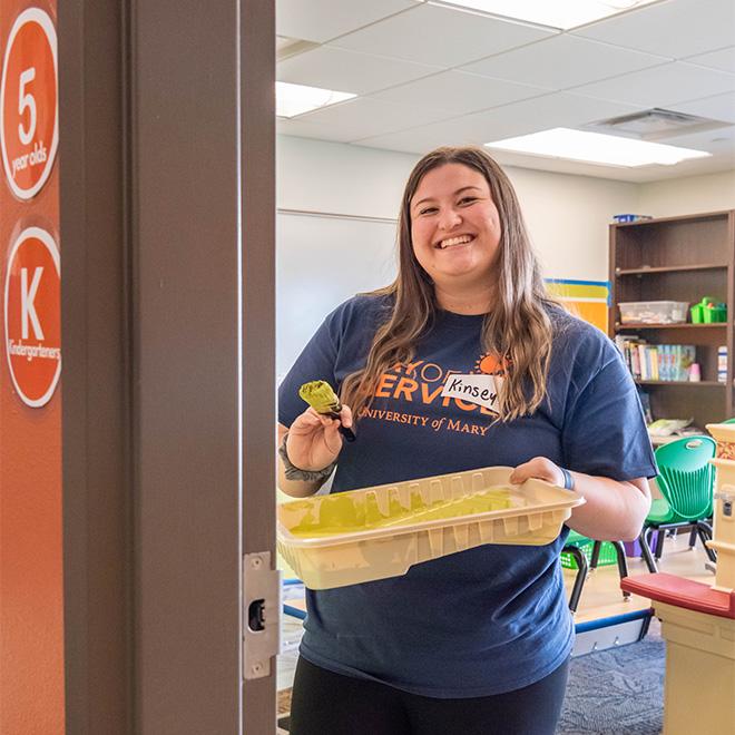 Student painting a classroom wall for day of service