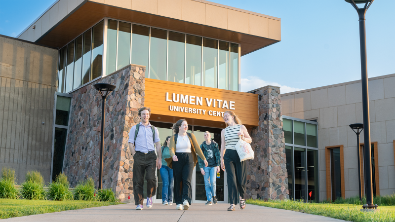 Students walking outside the lumen vitae center.