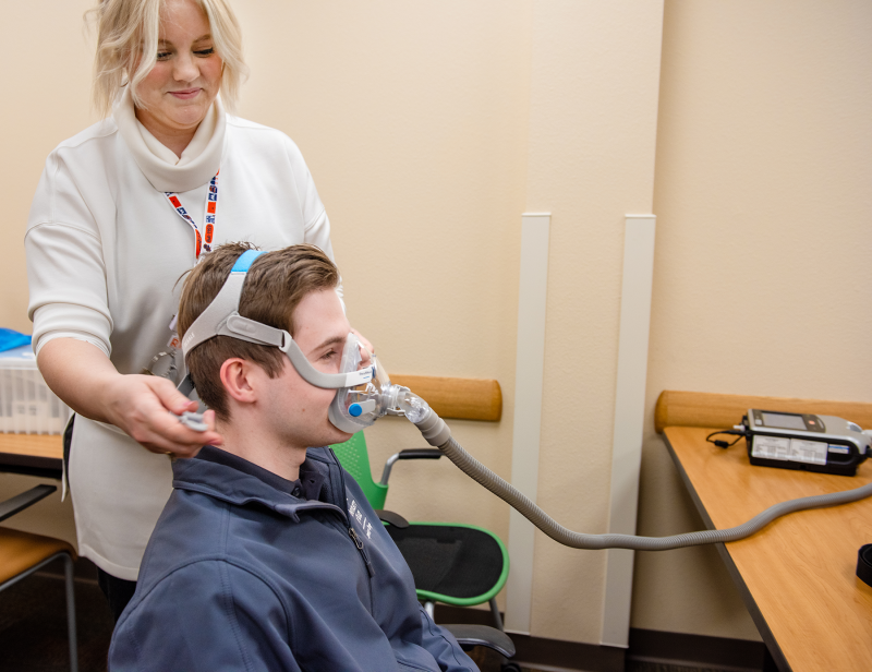 Professor working with a student on experiencing a breathing mask