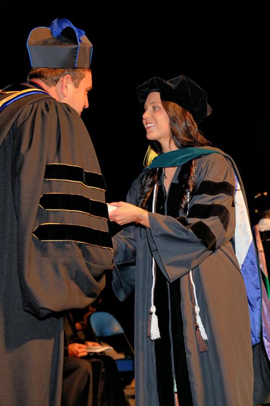 student greeting Monsignor during commencement