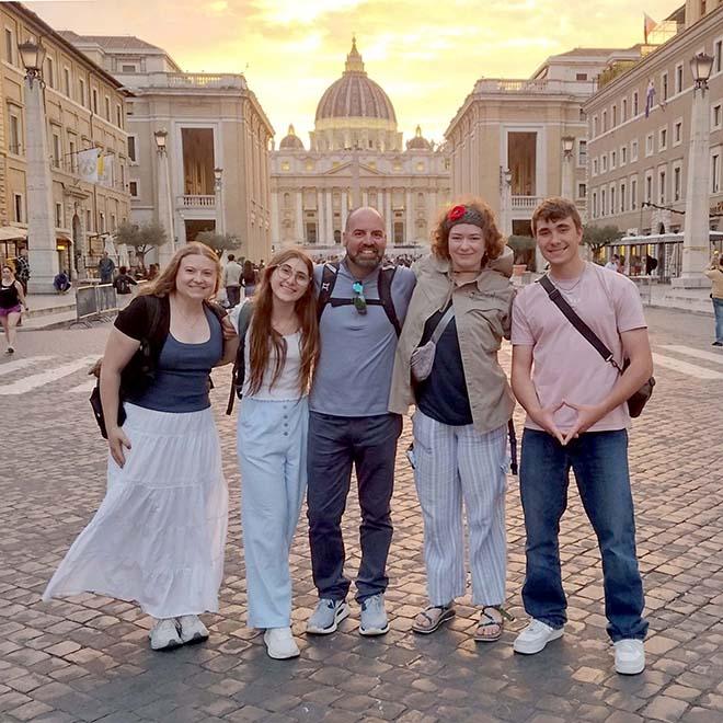 Engineering students with faculty on a pilgrimage in Rome standing in front of St. Peter's Basilica