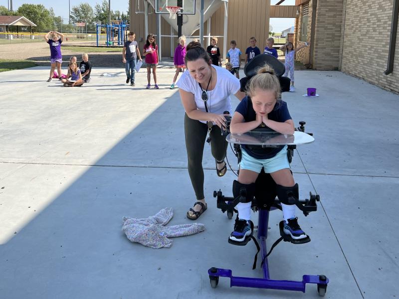 Third-grade teacher Jill Wall assists a student with a science experiment.