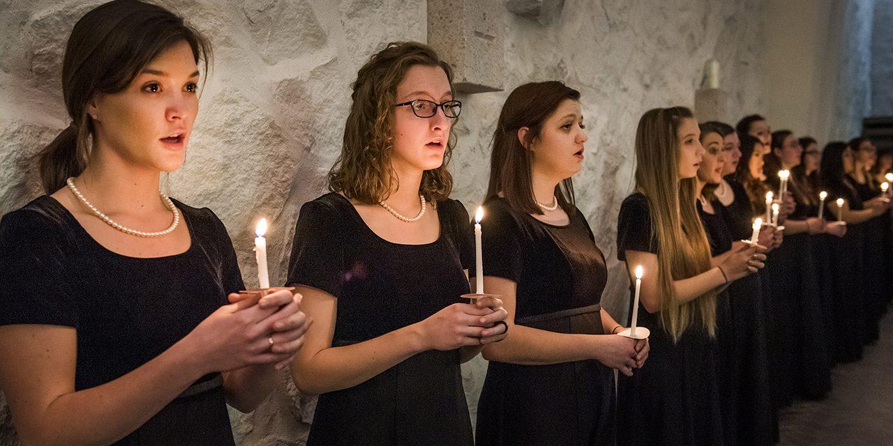 Choir singing with lit candles