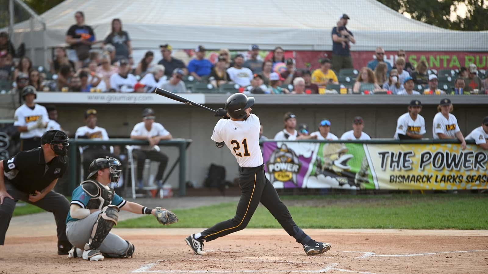 Crowded baseball game with batter in full swing