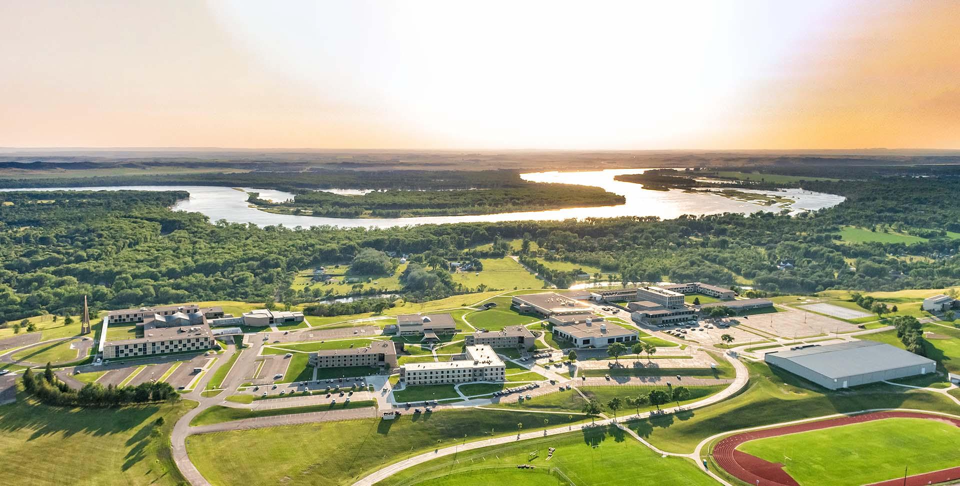 Aerial of the University of Mary campus at sunset with the Missouri River in the background