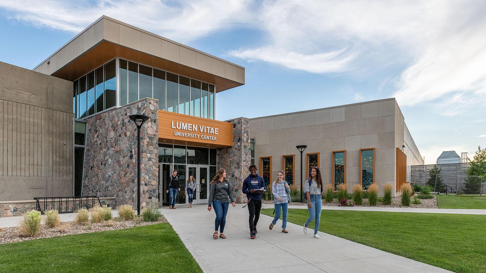 Diverse group of happy students leaving university center