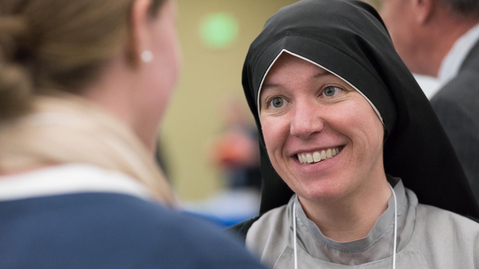 A visiting sister talking with a University of Mary student.