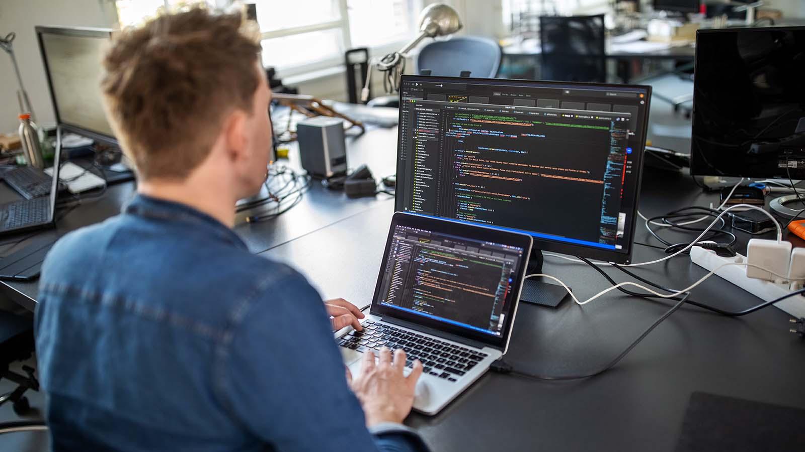 Male professional sitting at his office desk and working on a new software program.