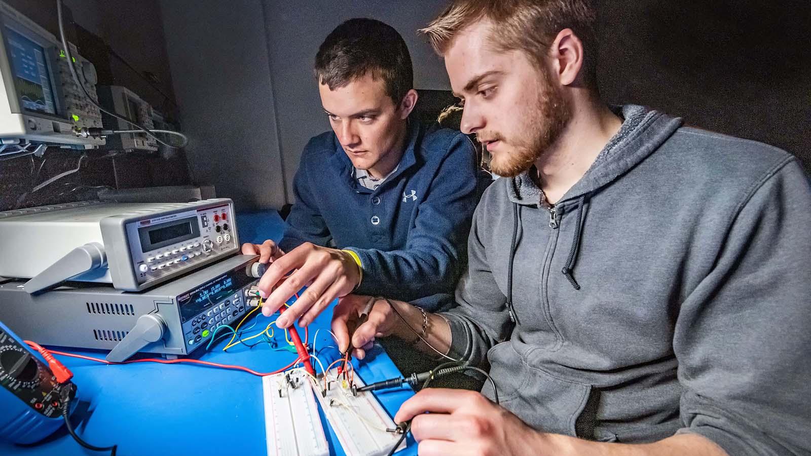 Two electrical engineering students working on project