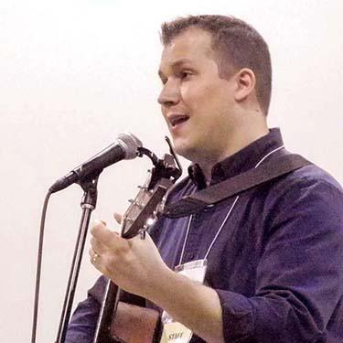 Photo of Marc Stockert singing and playing guitar