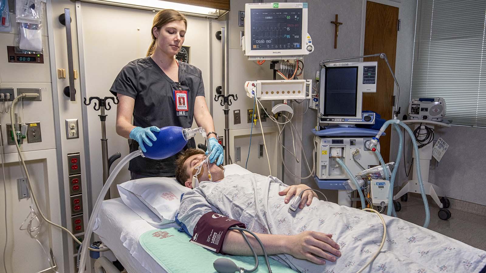 Respiratory therapist intubating patient in hospital