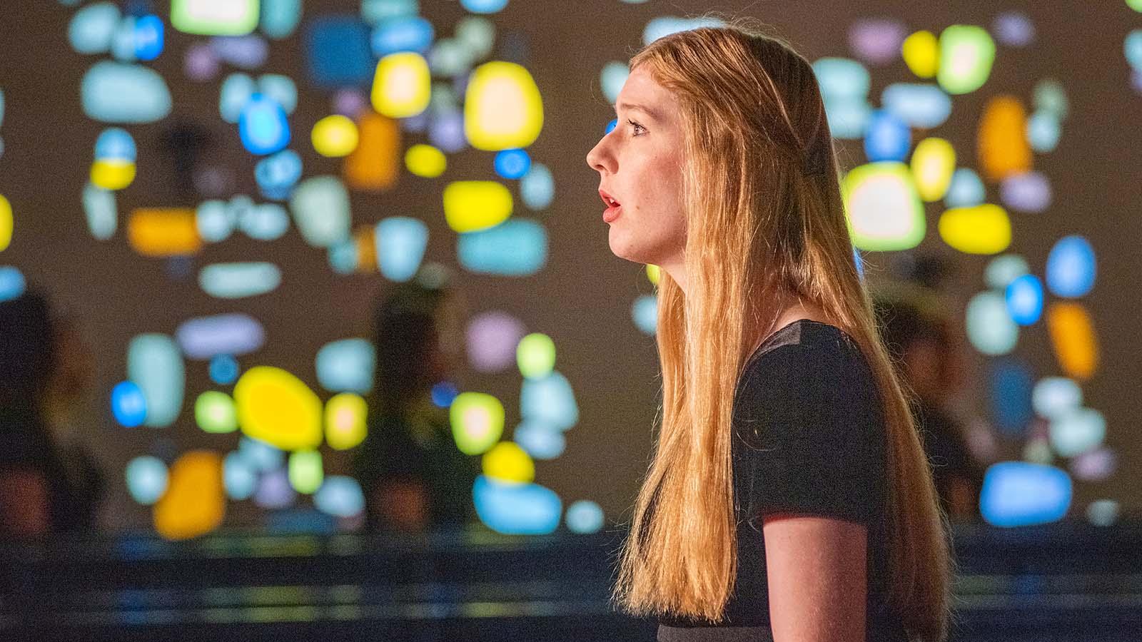Female student singing in chapel