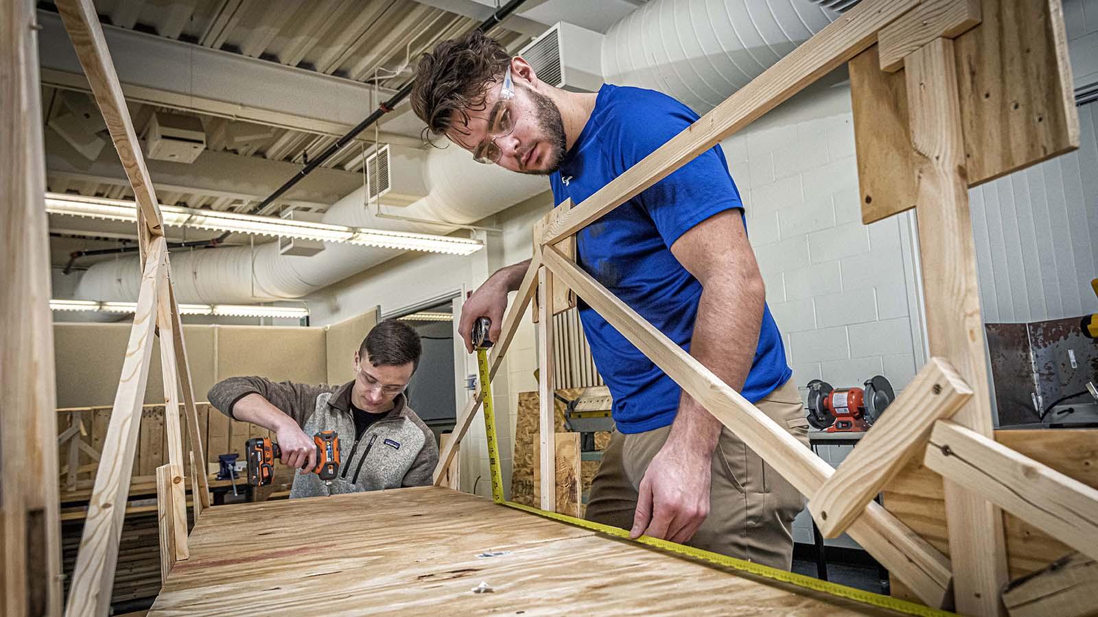 Civil engineering students building model of a bridge