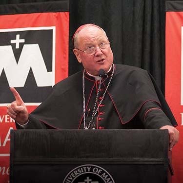 Cardinal Dolan at podium addressing students and guests