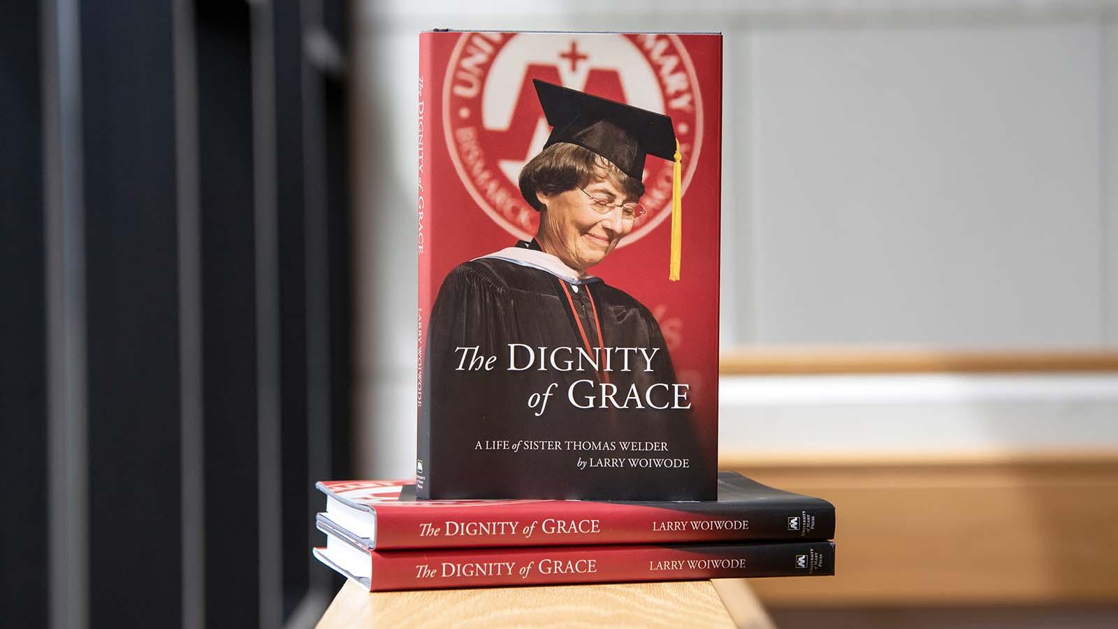 Closeup of stack of Dignity of Grace books on ledge.