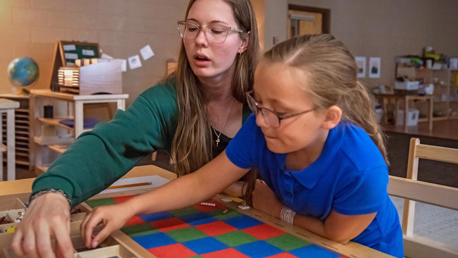 Elementary teacher helping a young student with project