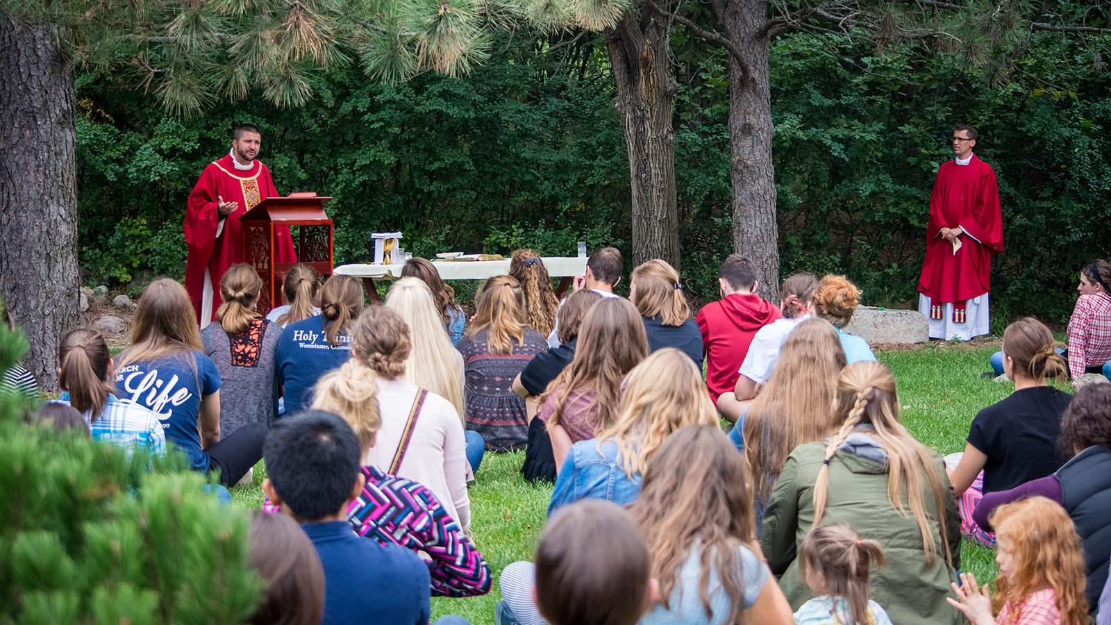 Group of students celebrating Mass outdoors
