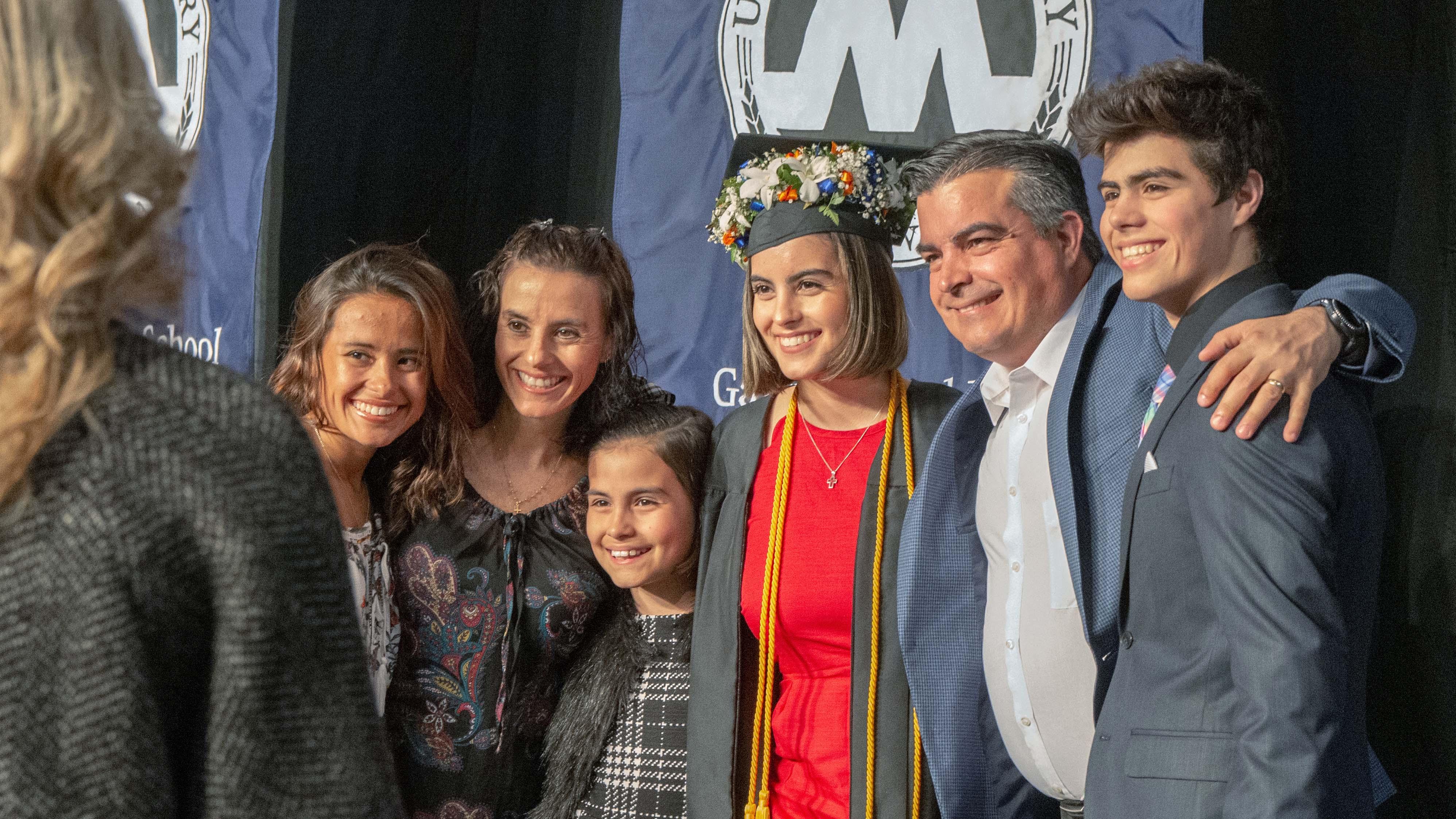 Graduate gathered with family for a photo at commencement