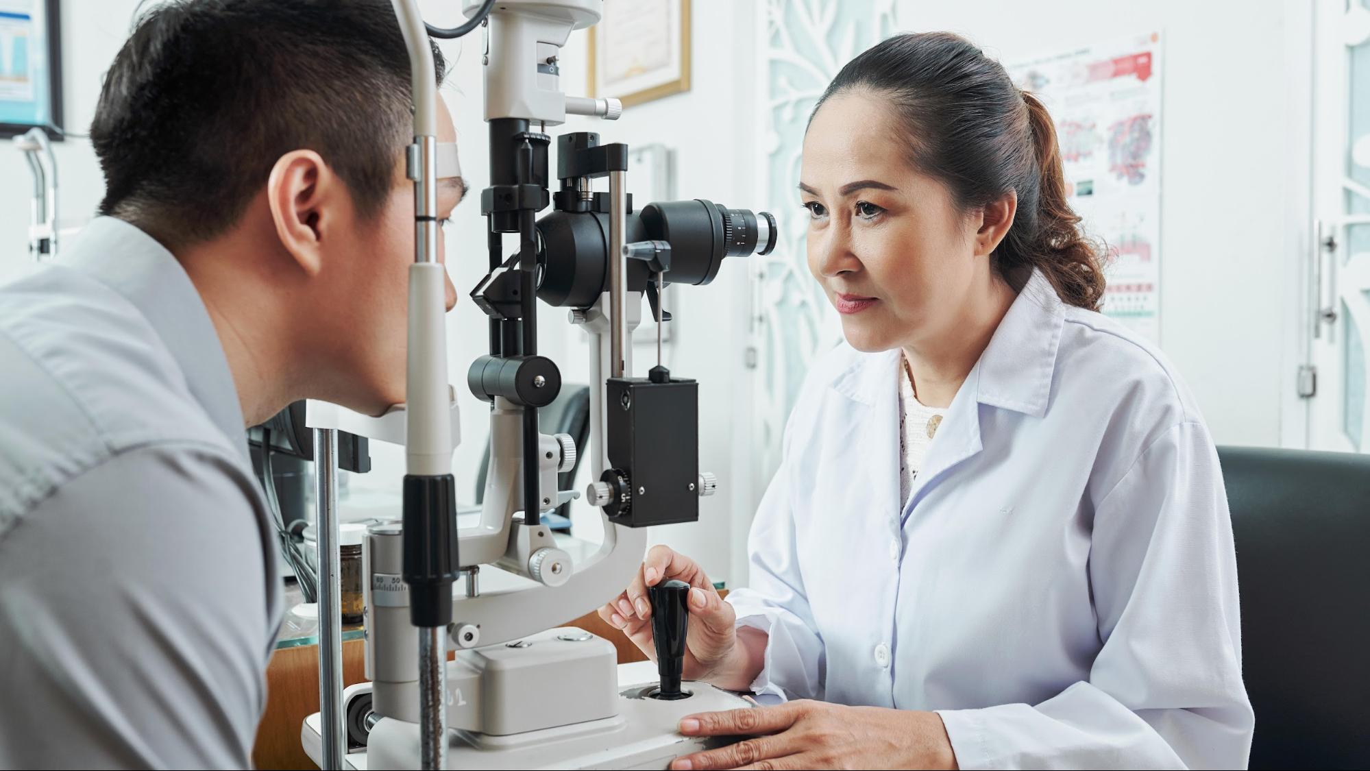 Optometrist giving eye exam to patient