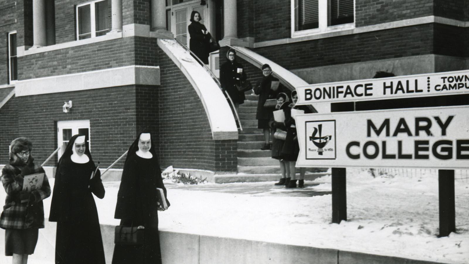 Historic image of Sisters and students standing outside Boniface Hall at the Mary College Town Campus
