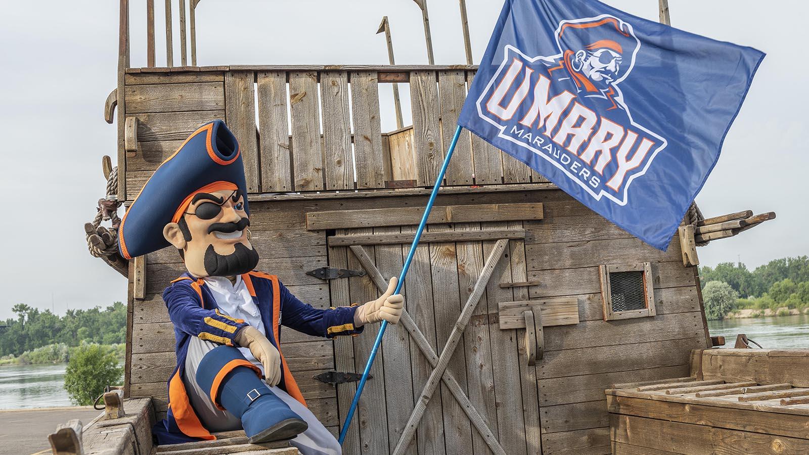 Max the Marauder holding the UMary Athletics flag.